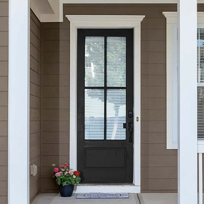 A residential home exterior in the house paint color Blackish, the perfect almost black paint color from Clare. Blackish is an almost black paint color that's less intense than true black, but bold enough to make a statement.