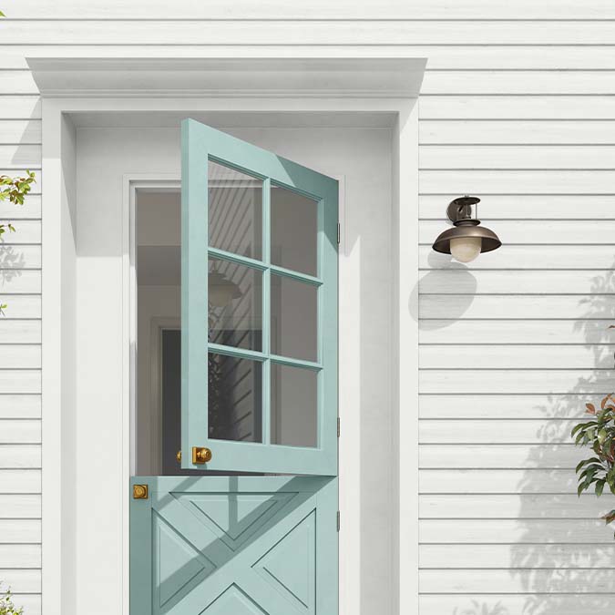 A residential home exterior in the house paint color Classic, the perfect dove gray beige paint color from Clare. Classic is a soft, timeless greige paint color that brings a clean, modern feel to any space.  Shop now.