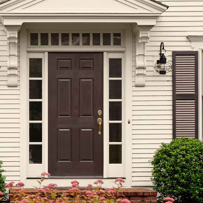 A residential home exterior in the house paint color Coffee Date, the perfect coffee brown paint color from Clare. Coffee Date is a rich, coffee brown paint color. Like a bold, complex dark roast, this color is sure to spark a conversation! Shop now.