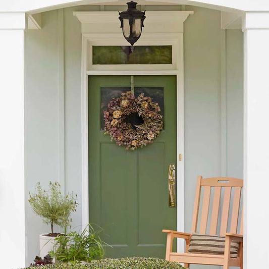 A residential home exterior in the house paint color Daily Greens, the perfect hunter green paint color from Clare. Daily Greens is the perfect hunter green paint color. Get your daily fix with this mossy olive green that’s the secret to a well-balanced space.