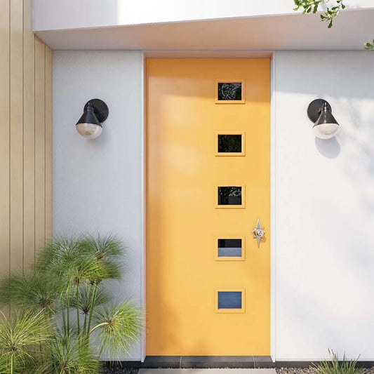 A residential home exterior in the house paint color Golden Hour, the perfect yellow paint color from Clare. Golden Hour is an stunning, golden yellow paint color. Like the warm glow of an unforgettable sunset, it’ll drench your space in lovely golden tones. Shop now.