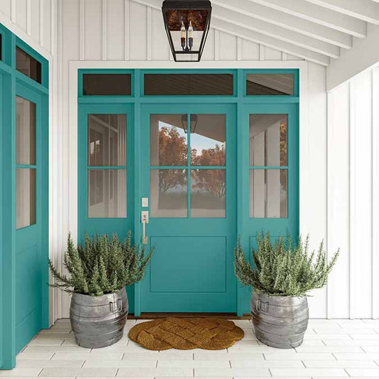 A residential home exterior in the house paint color Keep It Teal, the perfect teal paint color from Clare. Keep It Teal is a striking teal paint color with the perfect amount of punch. Bring in a burst of color with this lively green-blue hue. Shop now.