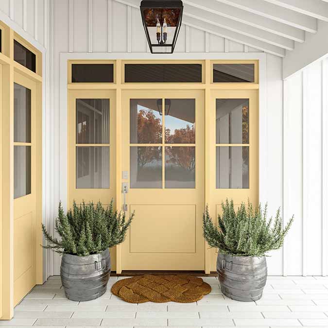 A residential home exterior in the house paint color Lemonade, the perfect yellow wall paint from Clare. Lemonade is a refreshing lemony yellow paint color inspired by the favorite summer drink.  Shop now.