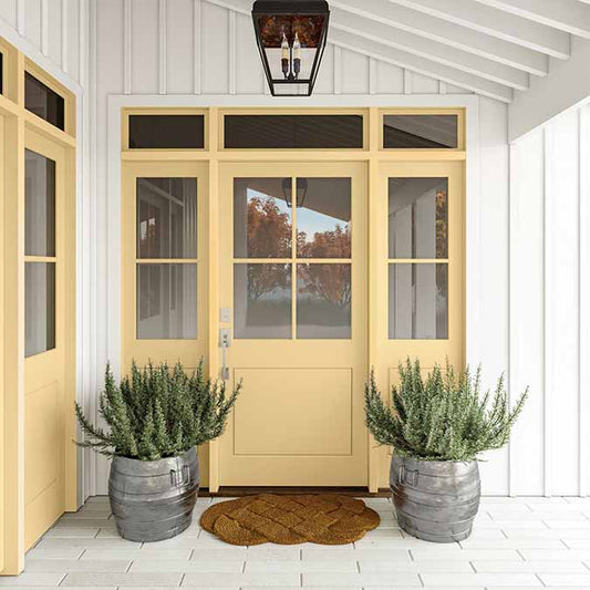 A residential home exterior in the house paint color Lemonade, the perfect yellow wall paint from Clare. Lemonade is a refreshing lemony yellow paint color inspired by the favorite summer drink.  Shop now.