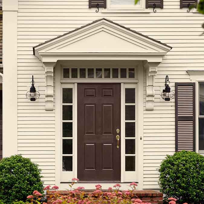 A residential home exterior in the house paint color Like Buttah, the perfect cream paint color from Clare. Like Buttah is the perfect cream paint color. This warm, buttery beige adds a rich boost of flavor to any room you roll it in.
